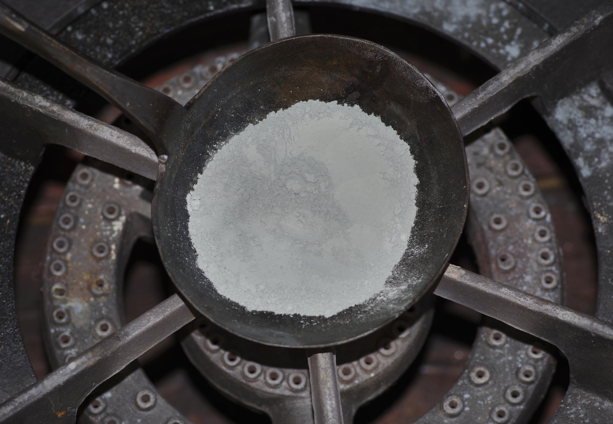 zinc powder heated in an iron pan on a stove